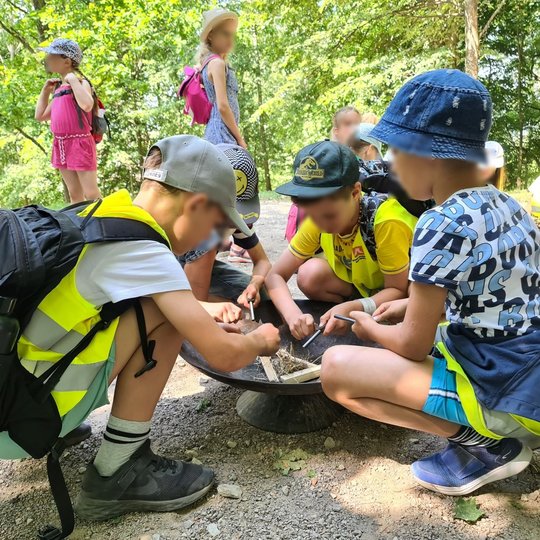 Vaikai nusprendė įkurti laužą komandiniu keliu - visi tūpė prie laužinės ir dirbo skiltuvais.