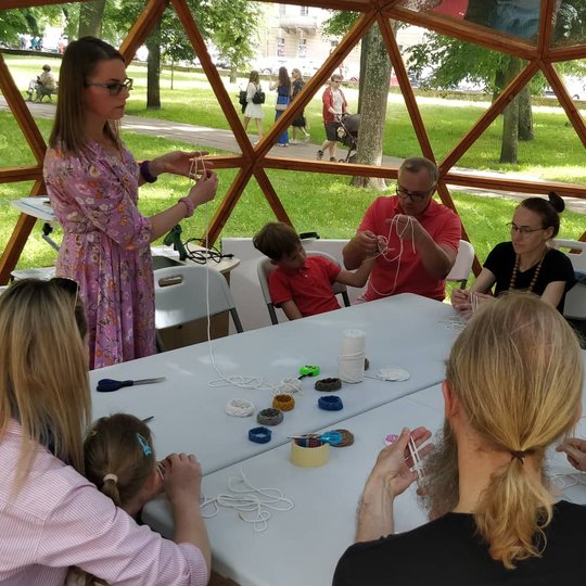 Vilniaus pilių kupole susirinkę dalyviai yra meistrės mokomi rišti mazgus.