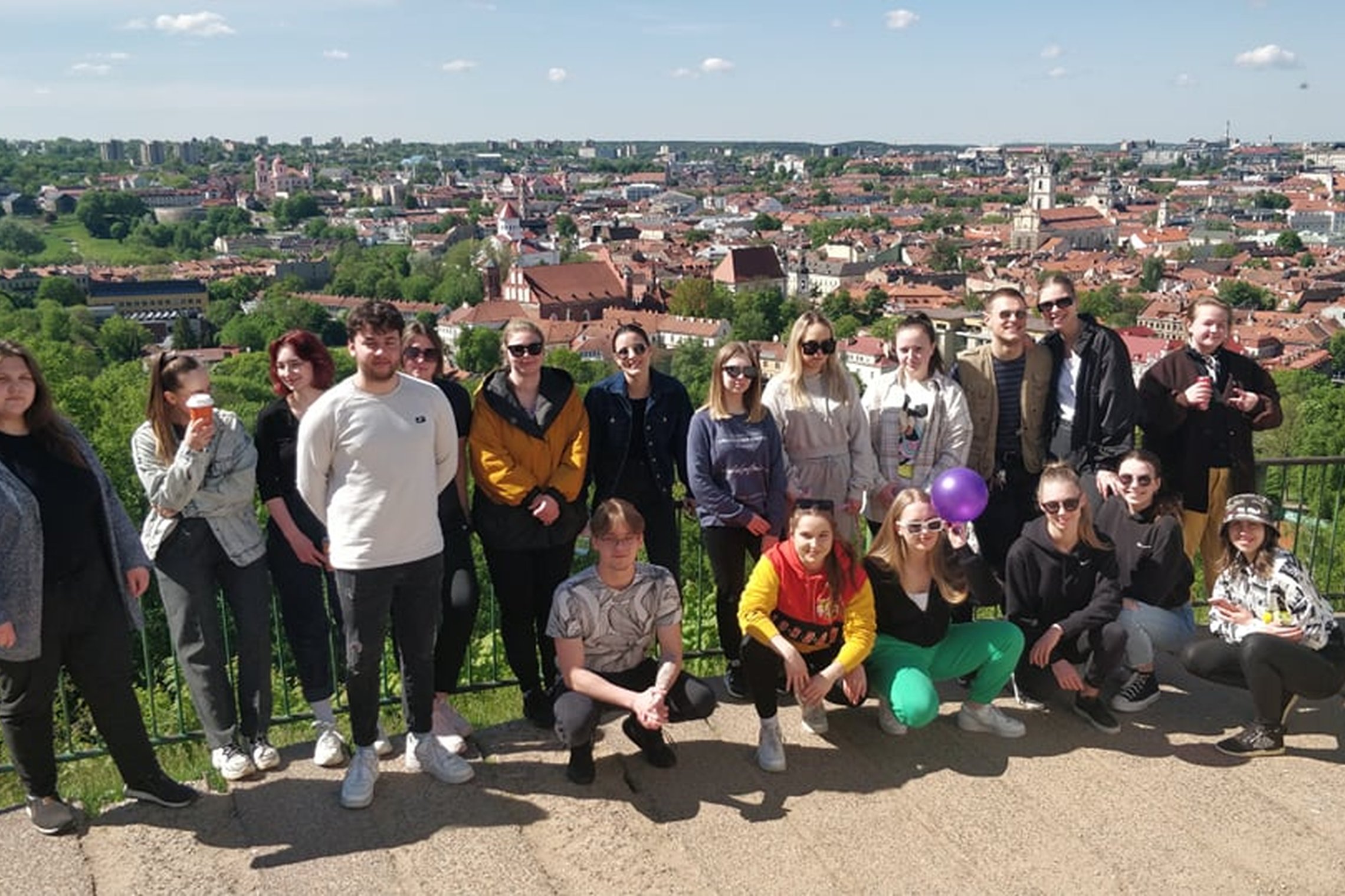 Studentai pozuoja nuotraukai nuo Trijų Kryžių panoramos.