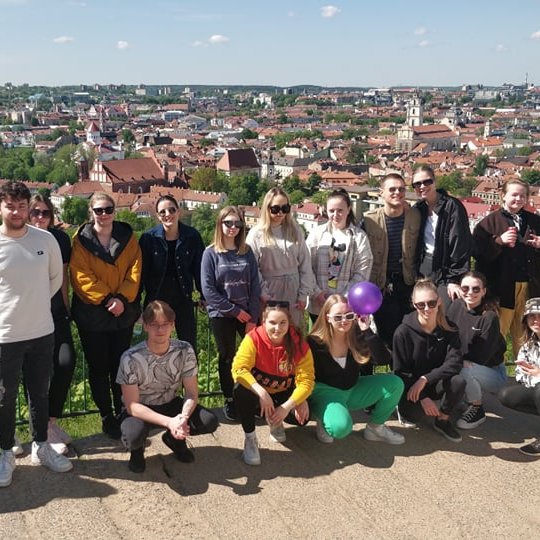 Studentai pozuoja nuotraukai nuo Trijų Kryžių panoramos.