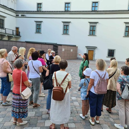 Išpasakota ir Valdovų rūmų istorija. Nuotraukoje grupė stovi Valdovų rūmų kieme.
