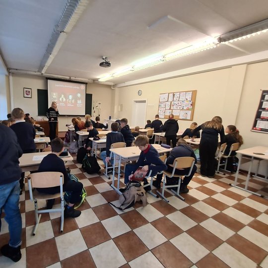 Vaikai klasėje dedasi vadovėlius į kuprines, ruošiasi kitai istorijos pamokos daliai.