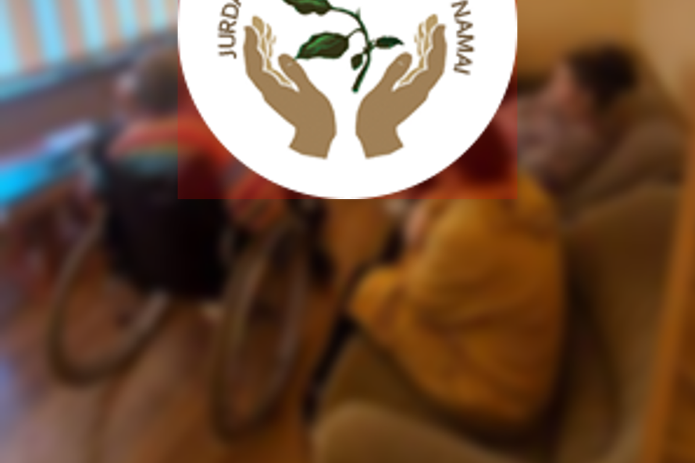 Jurdaičių socialinės globos namų gyventojai klausosi paskaitos. Nuotraukos priekyje slaugos namų logotipas.