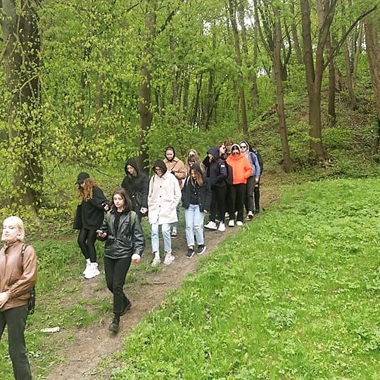 Studentai leidžiasi nuo kalvos. 