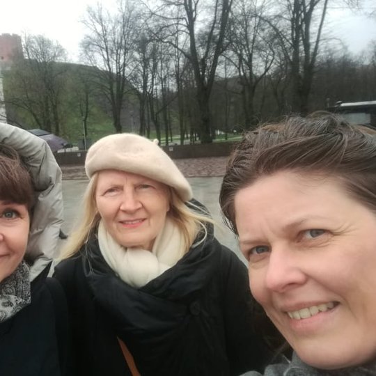 Dvi moteris su edukatore Angele šalia pietinių vartų į pilies teritoriją.
