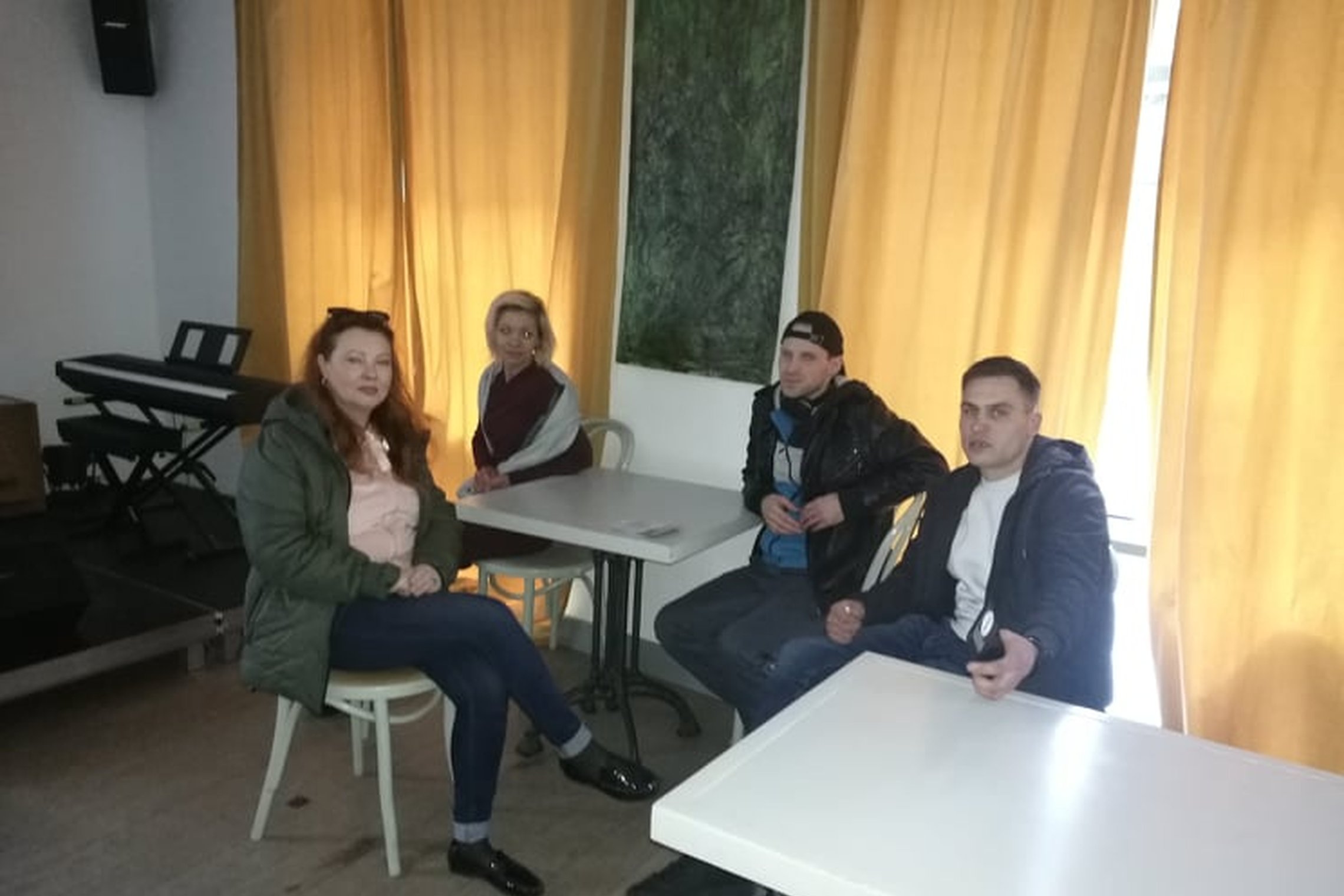 „Mano guru“ lankytojai sėdi prie stalų.