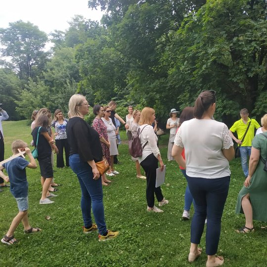 Grupė žmonių klausosi pasakojimo apie Gedimino sapną ant Stalo kalno. 