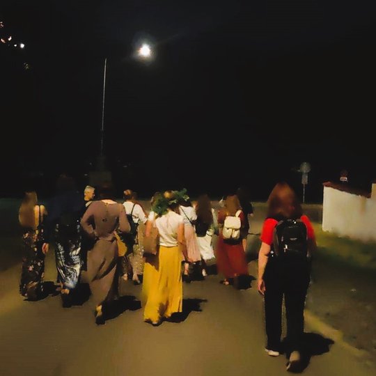 Naktinės ekskursijos metu, žmonės eina keliu iš Kalnų parko.