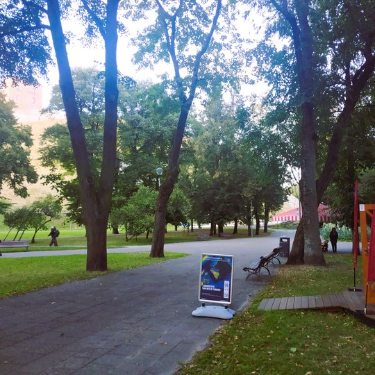 Vilniaus pilių kupolas iš laiko. Ant takelio matosi padėtas stendas su paskaitos afiša. Kairėje matosi Gedimino kalnas.
