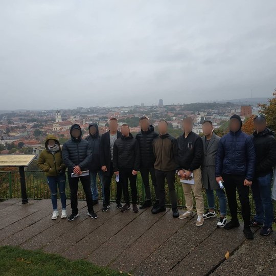 Lietinga vakarą, ant Trijų Kryžių kalvos, 4 kurso karo akademijos kadetai pozuoja nuotraukai. Jiems už nugarų Vilniaus panorama.