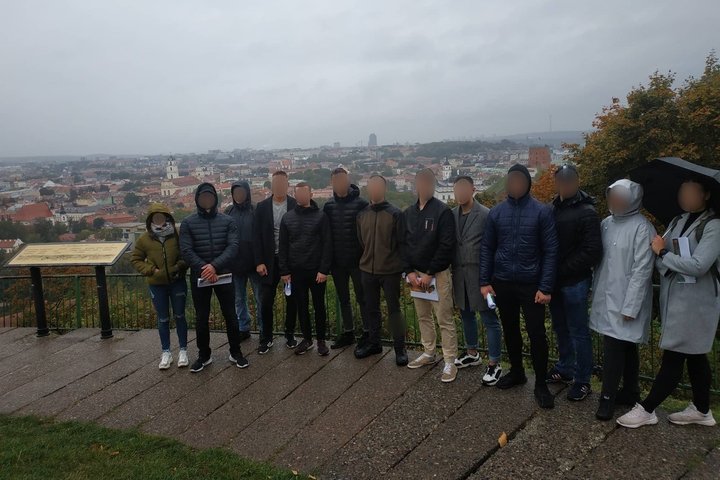 Lietinga vakarą, ant Trijų Kryžių kalvos, 4 kurso karo akademijos kadetai pozuoja nuotraukai. Jiems už nugarų Vilniaus panorama.