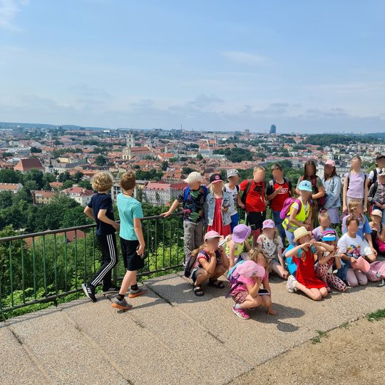 Viena grupė prie Vilniaus senamiesčio panoramos ant Trijų kryžių kalno.