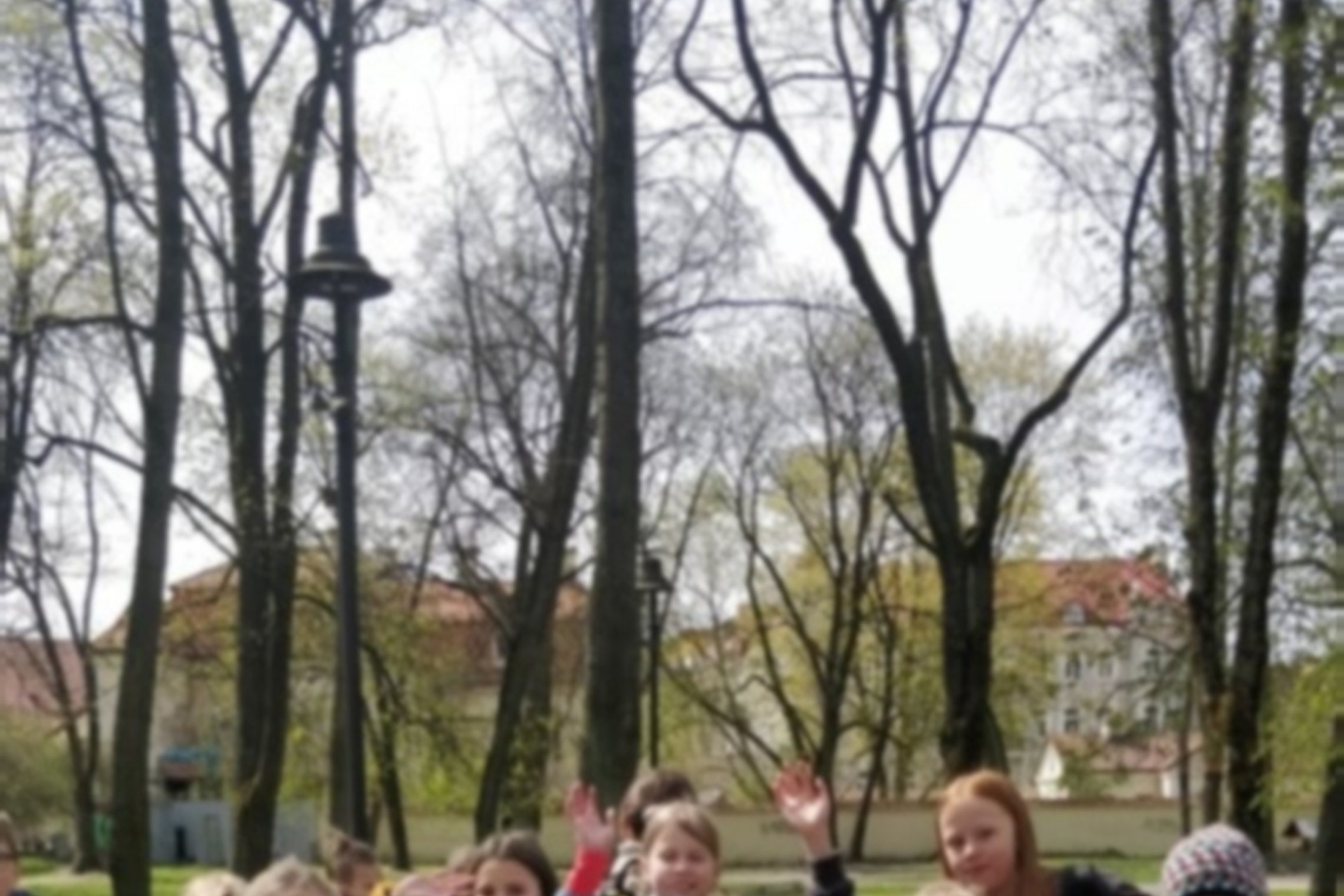 Mokiniai pozuoja nuotraukai lauke.
