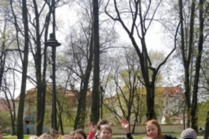 Mokiniai pozuoja nuotraukai lauke.