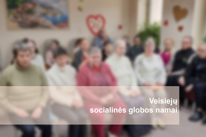 Veisiejų socialinės globos namų gyventojai salėje. Nuotraukos apačioje parašyta "Veisiejų socialinės globos namai".