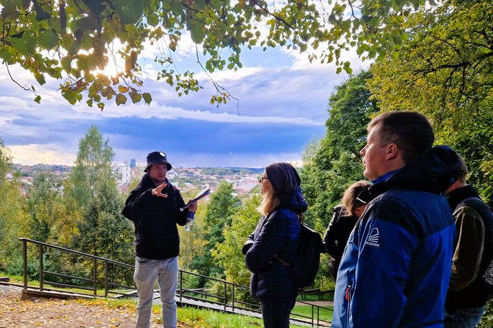 Gidas pasakoja apie Altanos kalno kalno istoriją ant Altanos kalno. Jam už nugaros Vilniaus senamiesčio panorama.