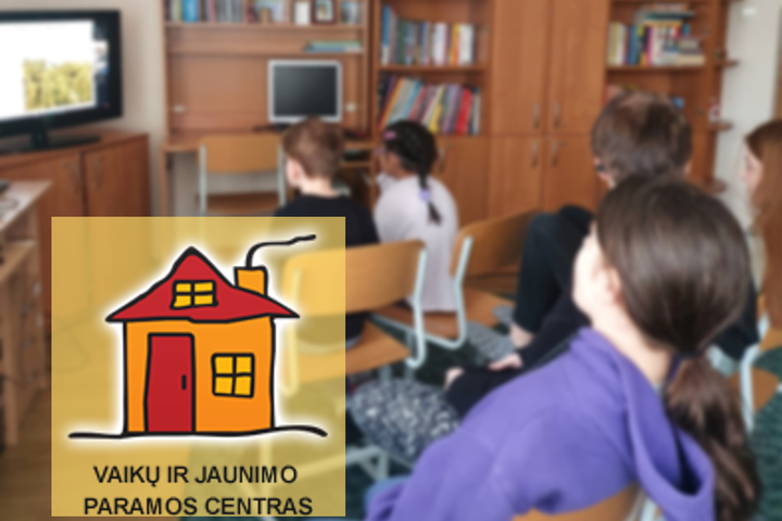 Vaikai kabinete žiūri į televizoriaus ekraną kampe. Nuotraukos kairėje, apačioje Katalikių moterų Vaikų ir jaunimo paramos centro logotipas.
