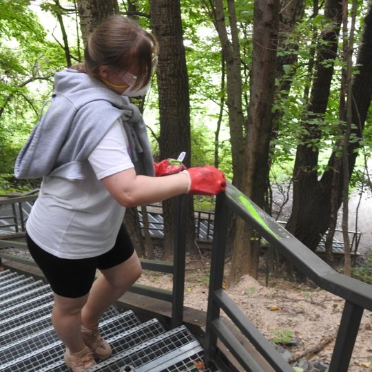 Savanorė stengiasi nuvalyti visus piešinius nuo turėklų.