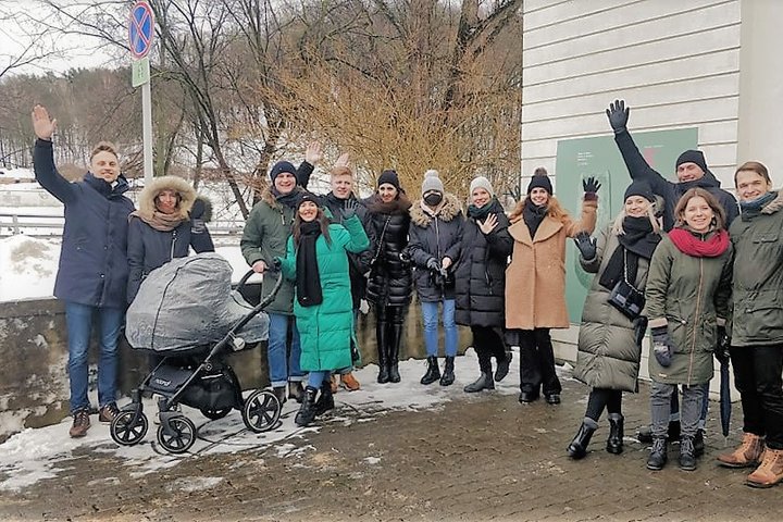 Ekskursijos dalyviai, užsidėję žiemiškus rūbus, pozuoja nuotraukai.