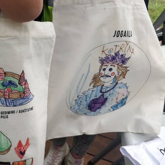 Nuspalvoti maišeliai, su Vilniaus pilimis ir Jogailos atvaizdu, ant vaikų nugarų.