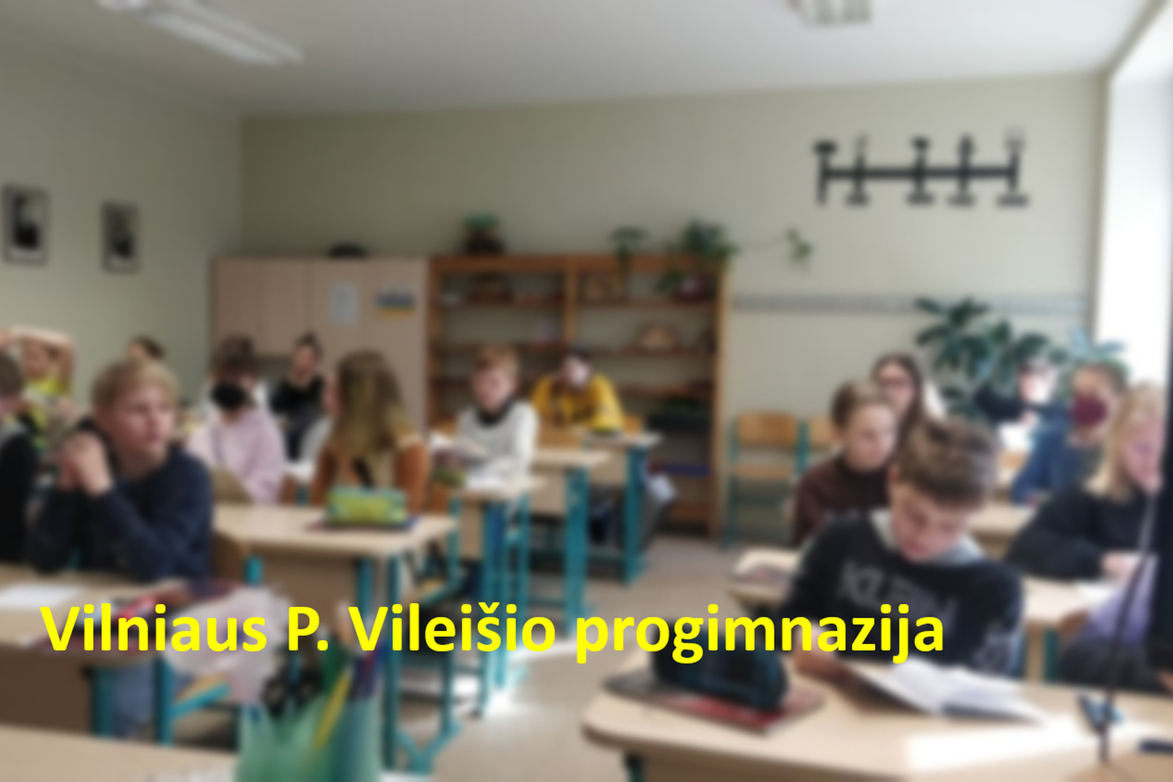 Penktokai klasėje. Nuotraukos priekyje geltomis raidėmis parašyta "Vilniaus P. Vileišio progimnazija".