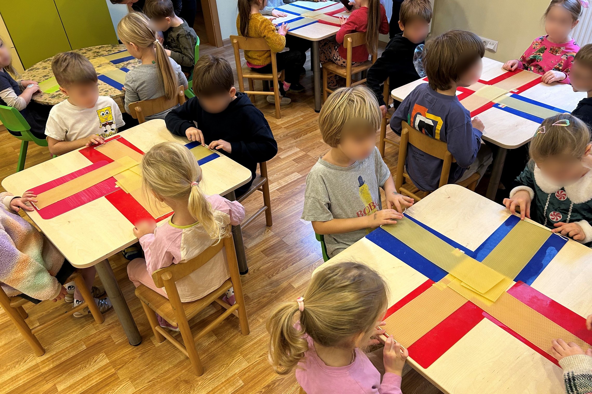 Nuotraukoje vaizduojami prie suolų sėdintys mokiniai. Visi mokiniai yra apsirengę žaliomis uniformomis. Klasės gale taip pat stovi Kalėdinė eglutė. Galima manyti, kad nuotrauka daryta šventiniu laikotarpiu.