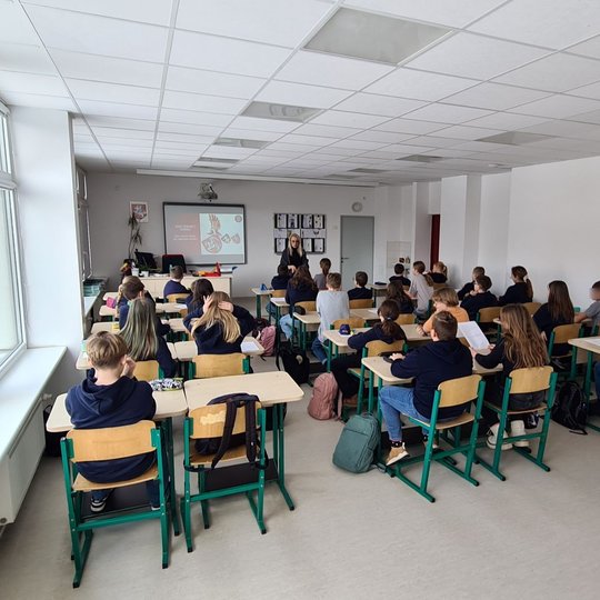 Penktokų klasė. Mokiniai sėdi suoluose ir klauso pamokos.