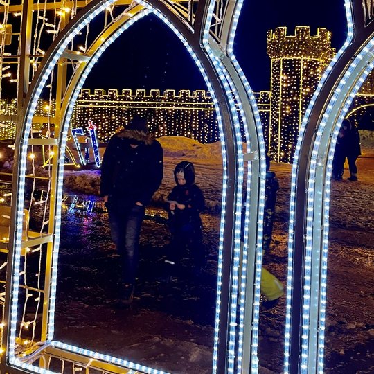 Vaikas ir tėtis stovi prie Kreivosios pilies instaliacijos vartų.