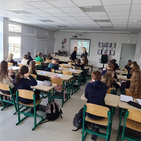Penktokų klasė. Mokiniai sėdi suoluose ir klauso pamokos.