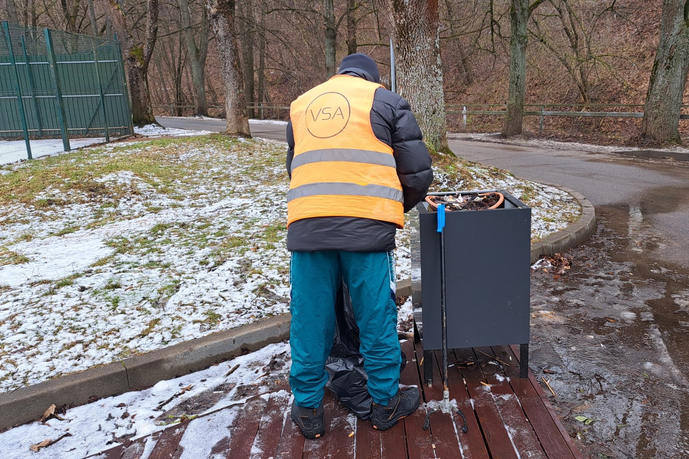 Rezervato tvarkytojas renka šiukšles iš lauko vazonų, esančių prie Bike Wash lauko kavinės.