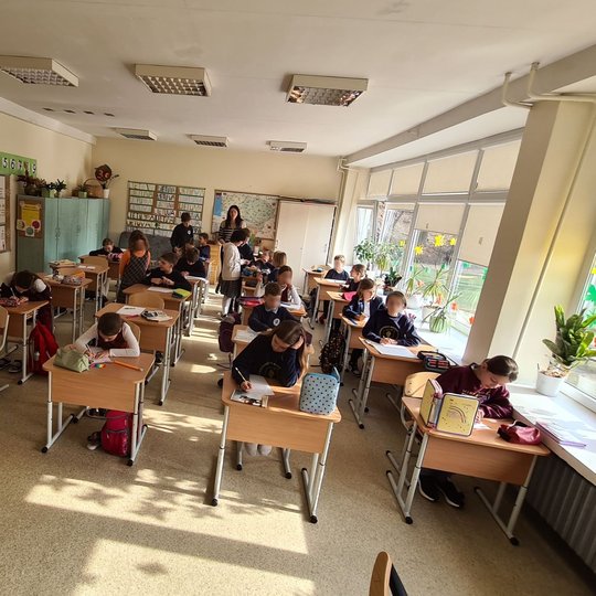 Trečiokai sėdi klasėje, istorijos pamokoje.