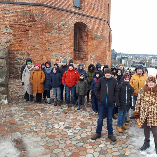 Ekskursijos grupė, sustojusi prie Gedimino pilies bokšto, ant Gedimino kalno.