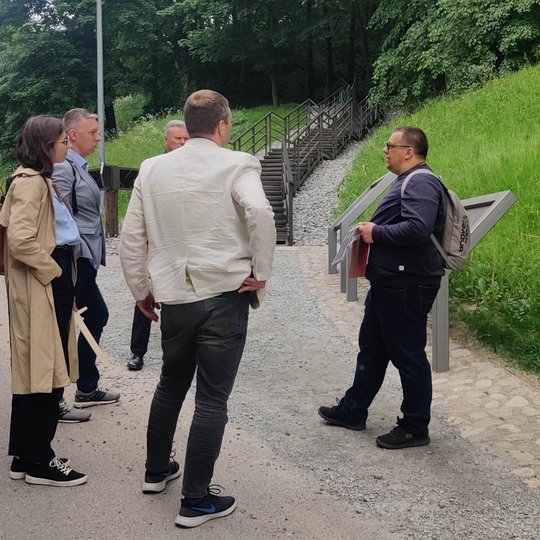 Ekskursijos dalyviai klausosi Vilniaus miesto istorijos įmantrybių prie Trijų kryžių kalno.