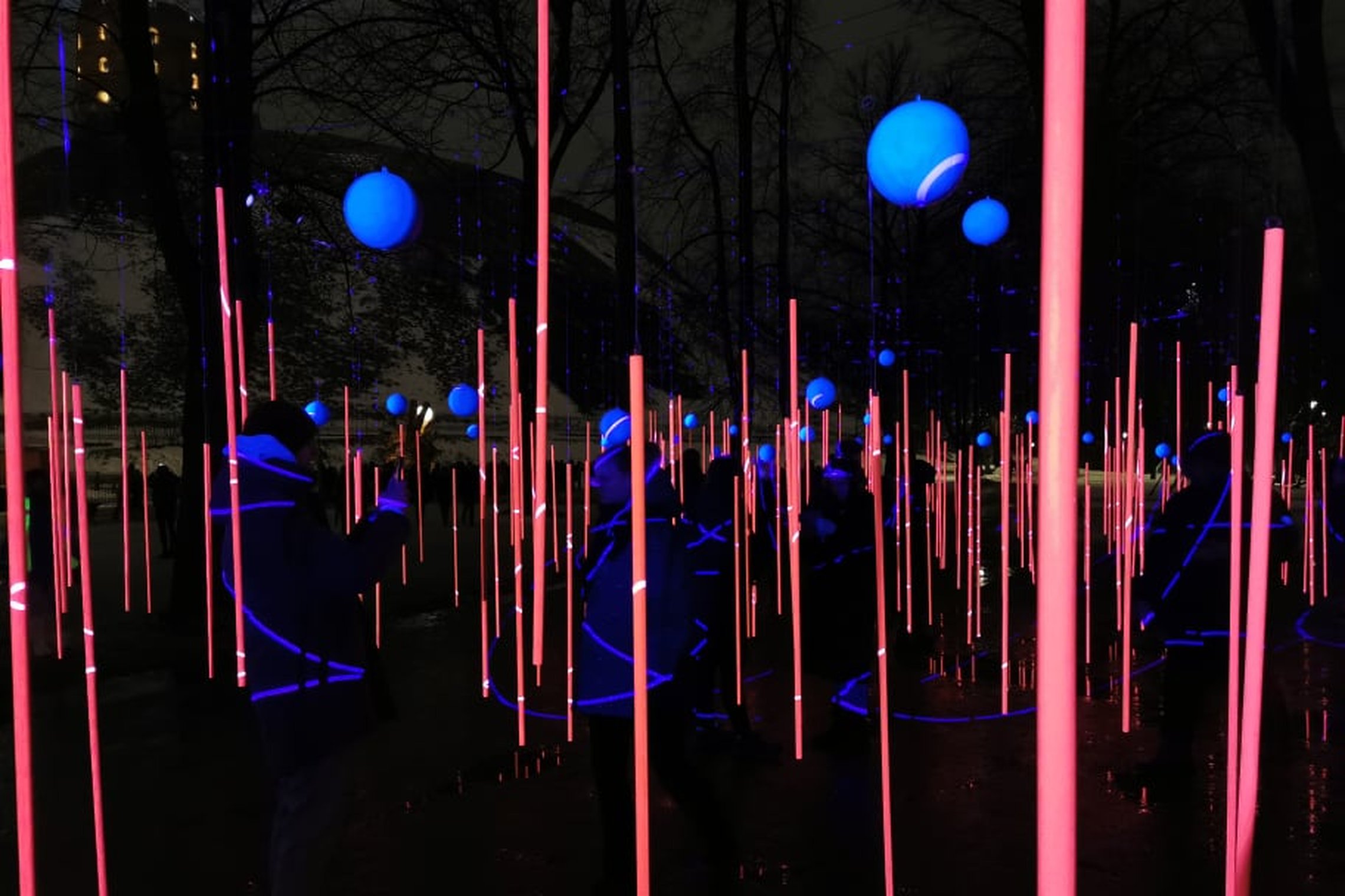 Vilniaus šviesos festivalio instaliacija - kabančios rožinės spalvos lazdelės. Kairiame kampe matosi Gedimino pilis.