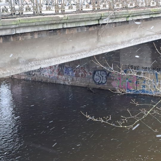 Tiltas prie Neries ir Vilnios upių santakos dar prieš sutvarkymą - ant jo betoninio pagrindo matyti gausybė graffiti piešinių.