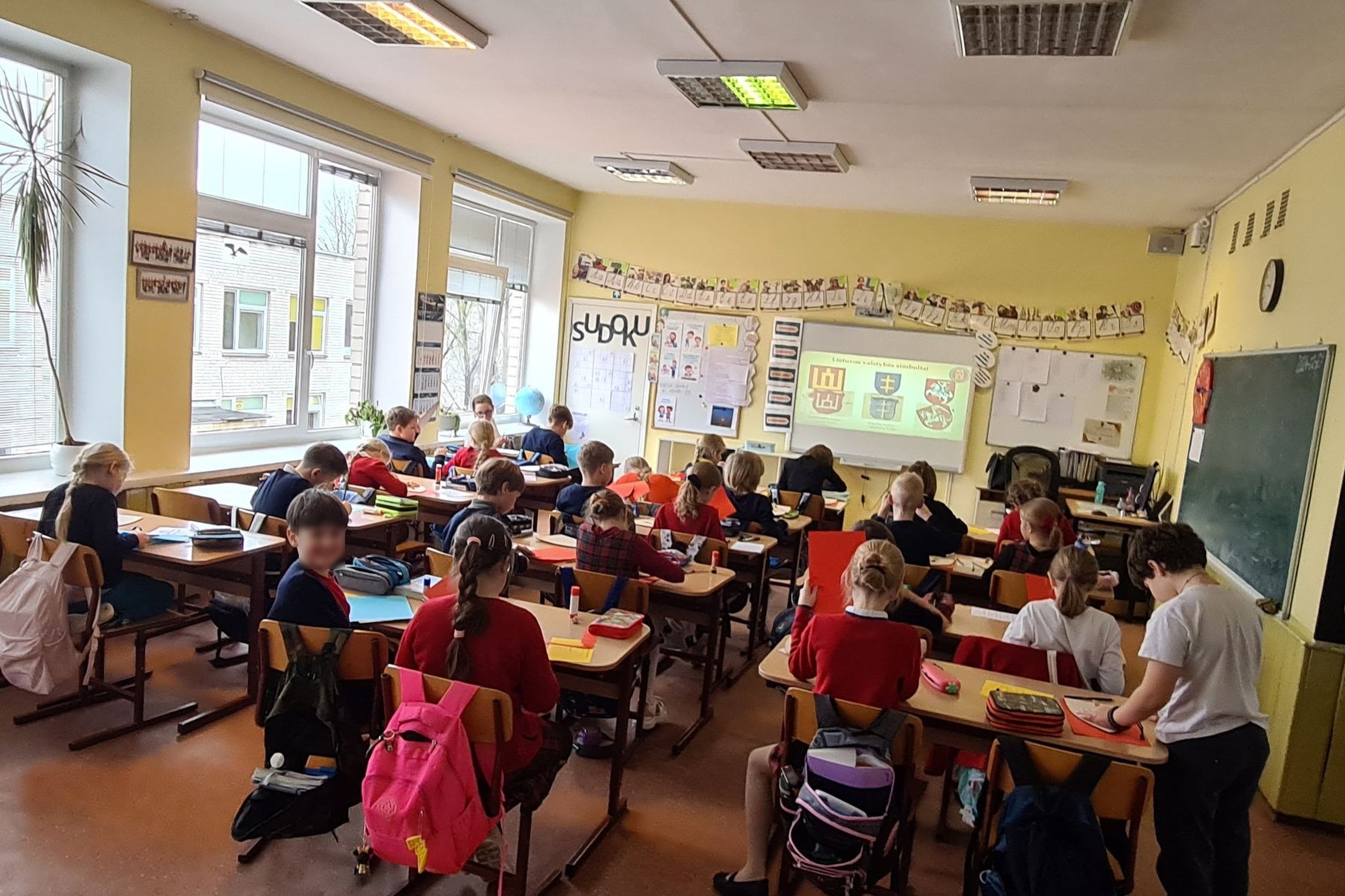 Trečiokai sėdi klasės suoluose.
