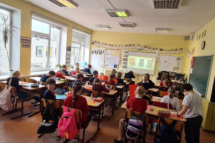 Trečiokai sėdi klasės suoluose.