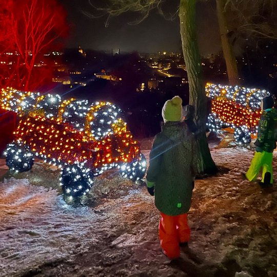 Trys berniukai prie švytinčių patrankų instaliacijų.