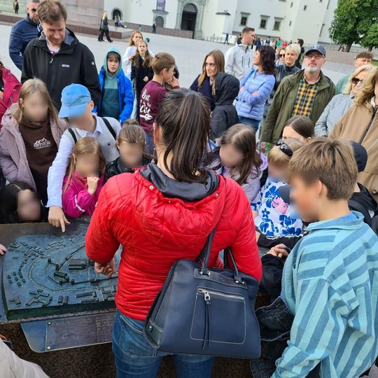 Mokiniai, mokytojai ir jų tėvai prie Vilniaus pilių maketo Katedros aikštėje.