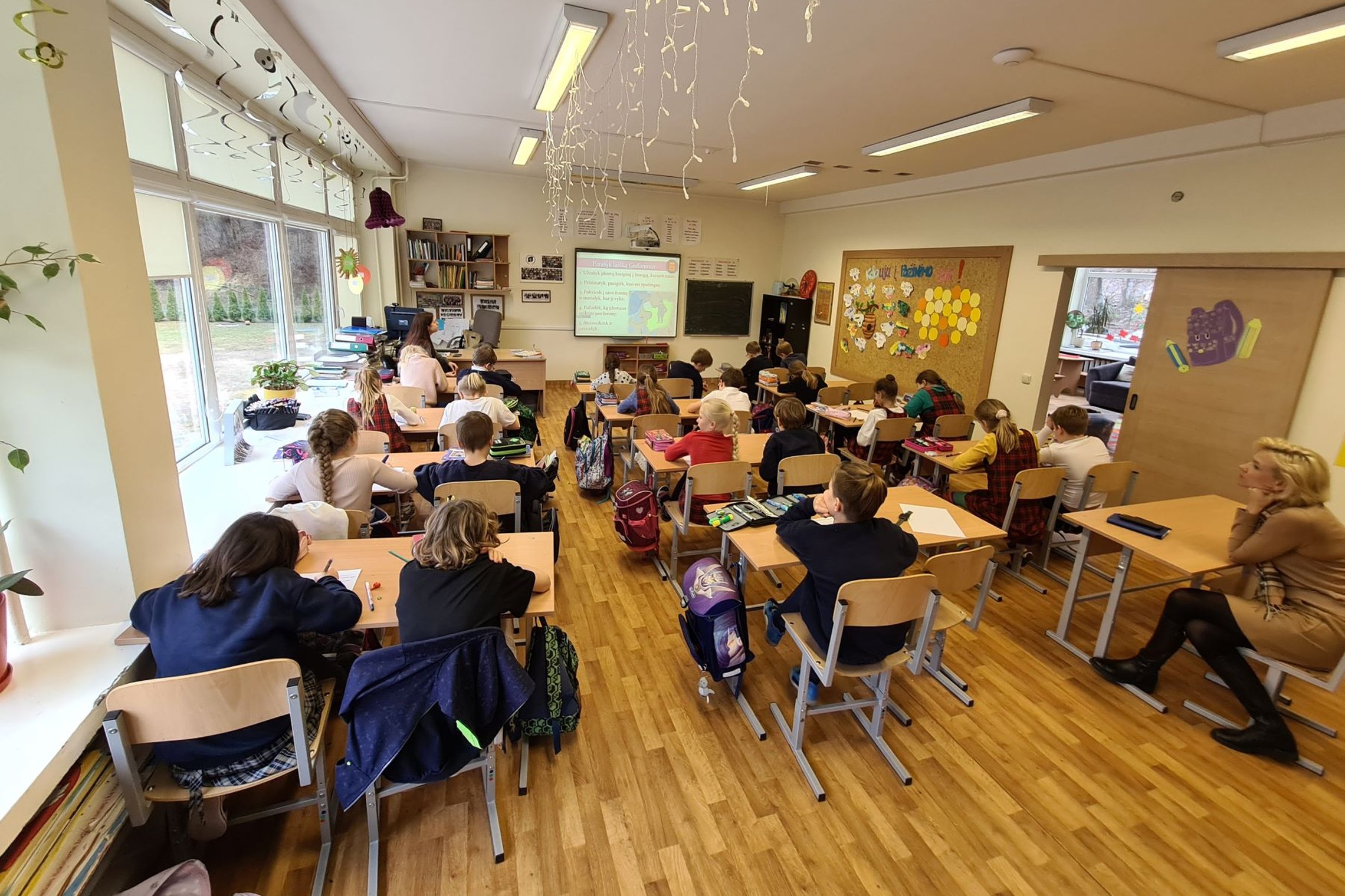 Trečiokai sėdi klasėje, vyksta istorijos pamoka.