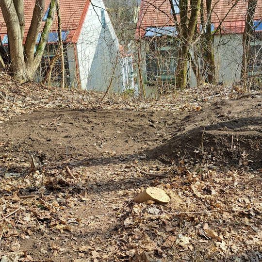 visas lauko tualetas užpiltas žemėmis, jo dešinėje pusėje suformuotas kaupas.