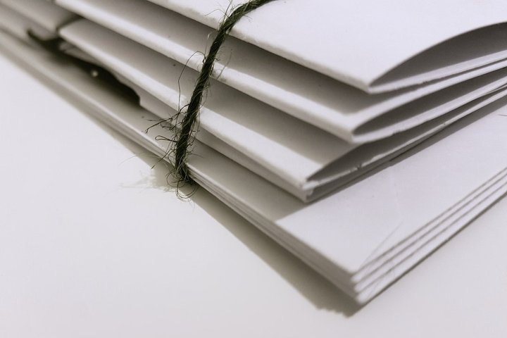 Siūlu surišti dokumentų aplankai. Asociatyvinė iliustracija iš Pexels. Autorius: The Chaos Painter.