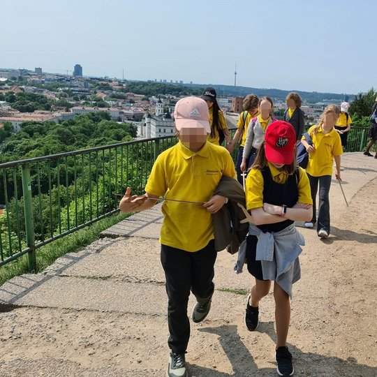 Mokiniai, po du, keliauja nuo Trijų kryžių kalno aikštelės.