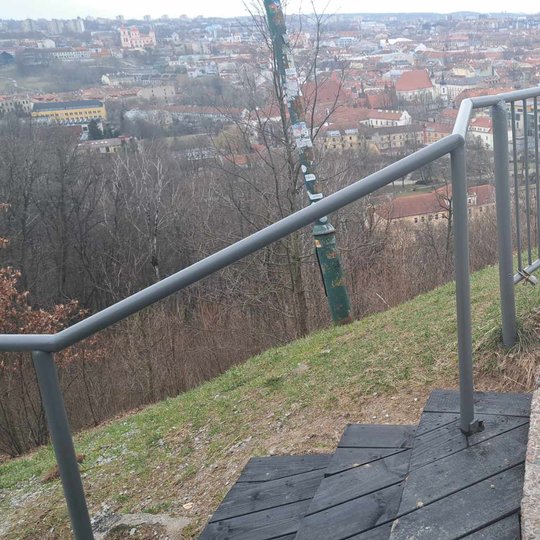 Nufotgorafuoti apžvalgos aikštelės turėklai. Jie nudažyti pilka spalva.