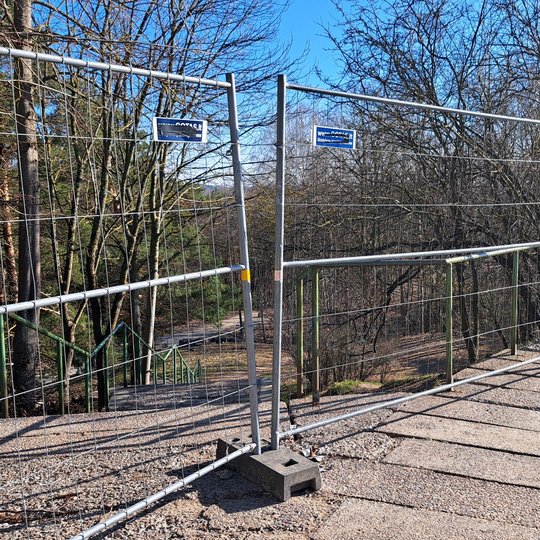 Nufotografuotas plyšys tarp dviejų segmentinių tvorų ant Trijų kryžių kalno apžvalgos aikštelės laiptų.