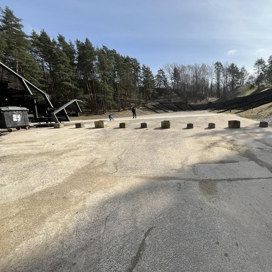 Vietoje estrados užtvaro išrikiuoti betoniniai lauko vazonai.