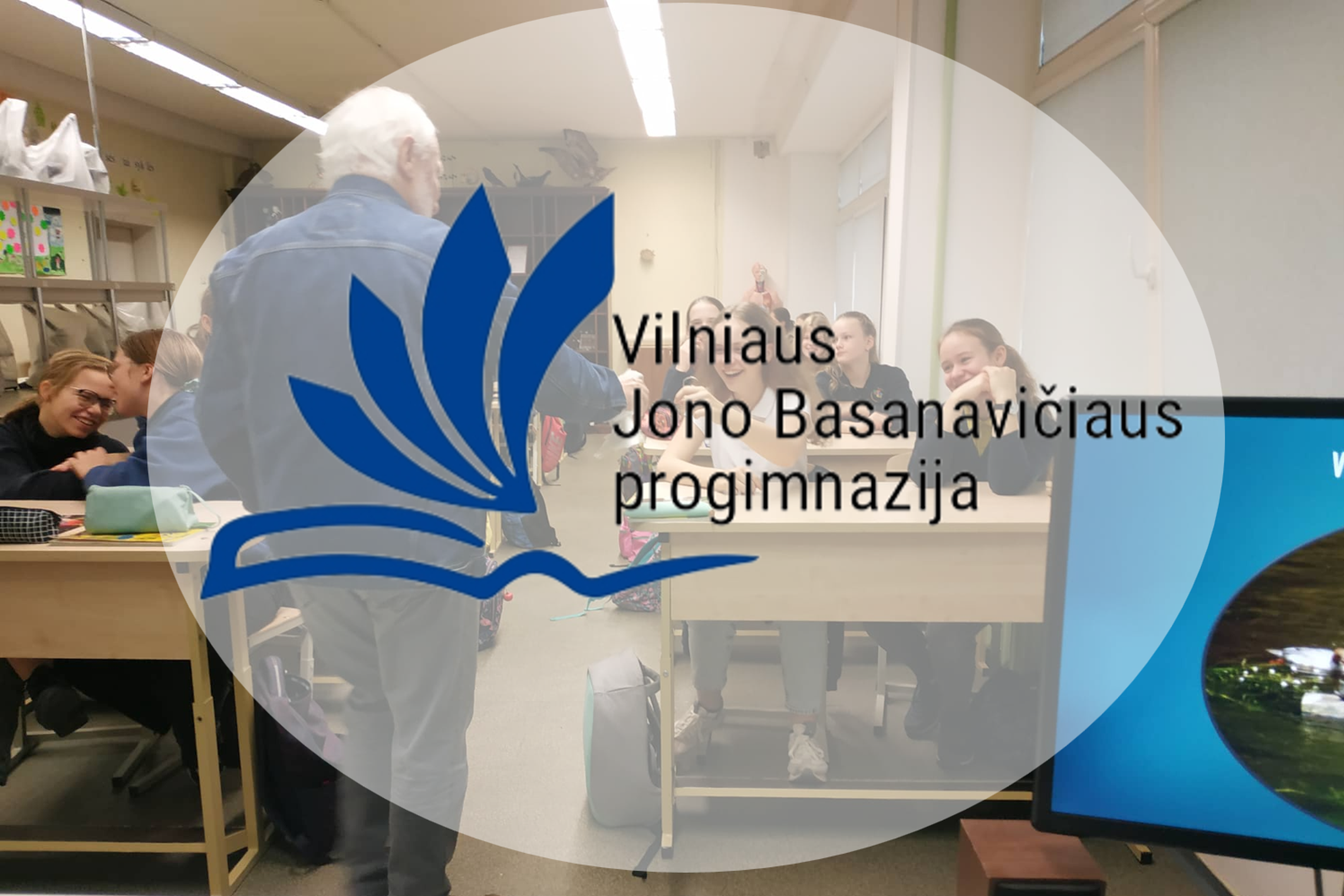 Nuotraukoje vaizduojamas Vilniaus Jono Basanavičiaus progimnazijos logotipas, už kurio mokiniai sėdi klasėje.