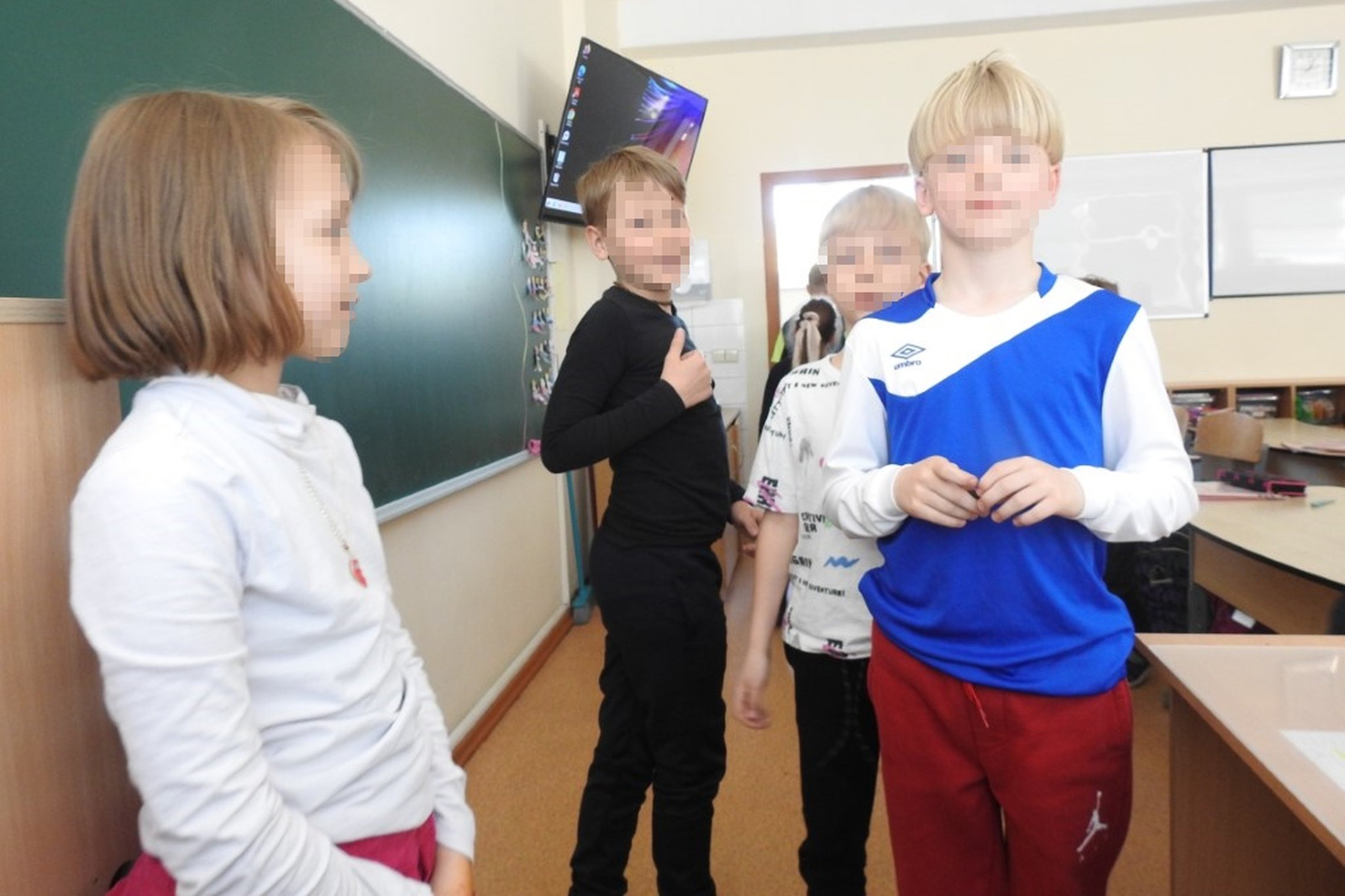 Antros klasės mokinukai, priėję prie mokytojo stalo dalinosi savo smalsumu.