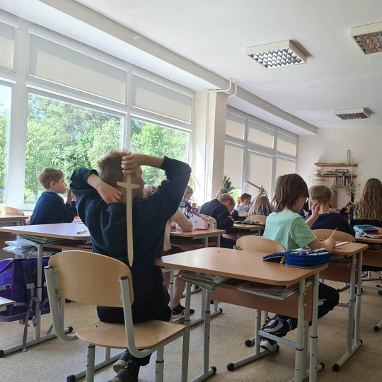 Mokiniai klasėje labai kantriai ir įdėmiai klausosi Vilniaus kalvų priešistorės.