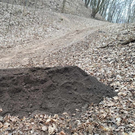 Augalinio grunto krūva, kuriuo buvo užpilamos skylės.